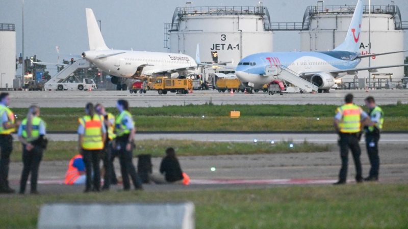 Climate activists on a tarmac at Stuttgart Airport. (Marius Bulling/picture alliance).